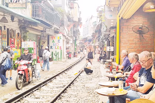 Những quán cà-phê sát đường tàu luôn tiềm ẩn nguy cơ tai nạn giao thông. Ảnh: VĂN HỌC 