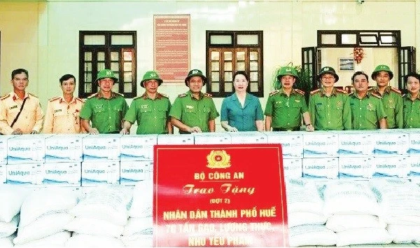 Thiếu tướng Nguyễn Hồng Nguyên (thứ 6 từ trái qua), Phó Chánh Văn phòng Bộ Công an trao 70 tấn gạo, lương thực và nhu yếu phẩm hỗ trợ người dân thành phố Huế. Ảnh HỒNG NHUNG