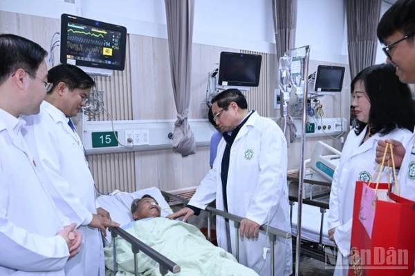 Thủ tướng Phạm Minh Chính thăm, tặng quà chúc Tết một bệnh nhân đang điều trị tại Trung tâm cấp cứu A9, Bệnh viện Bạch Mai. (Ảnh: Trần Hải)