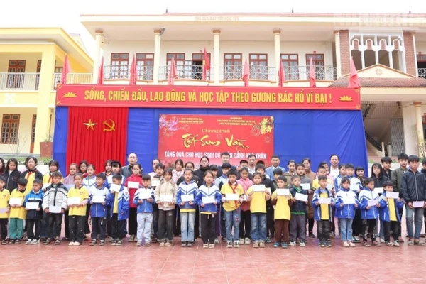 Đại diện các đơn vị trao tặng quà Tết cho 62 em học sinh có hoàn cảnh khó khăn tại Trường tiểu học và trung học cơ sở Chiềng Ngần A. (ẢNH: PHAN THẢO)