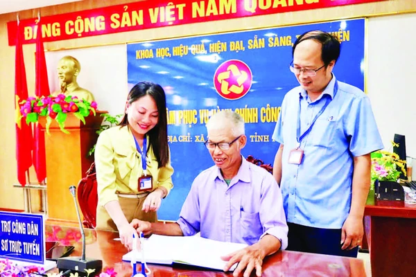 Cán bộ Trung tâm Phục vụ hành chính công xã Tam Nông hỗ trợ người dân thực hiện các thủ tục hành chính.