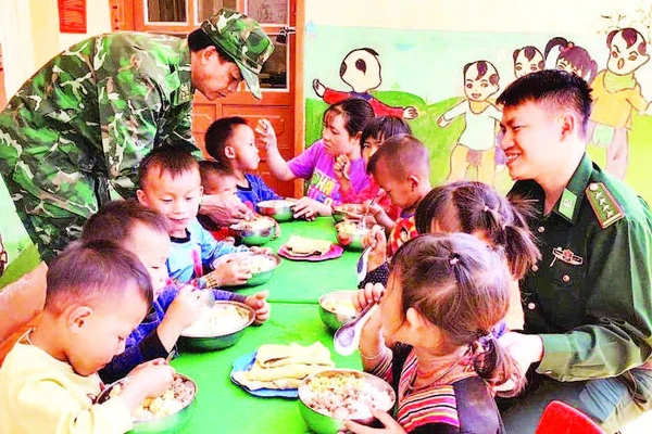 Thiếu tá Cầm Bá Thành (bên phải ảnh) cùng với đồng đội thực hiện “Bữa sáng cho em” tại điểm Trường mầm non Buốc Pát.