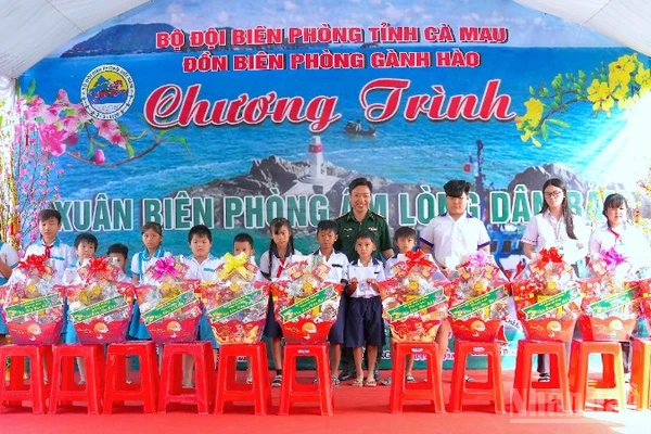 Đại tá Phạm Minh Giang, Chính ủy Bộ đội Biên phòng Cà Mau (đứng giữa) trao quà tặng học sinh nghèo vùng ven biển Gành Hào.