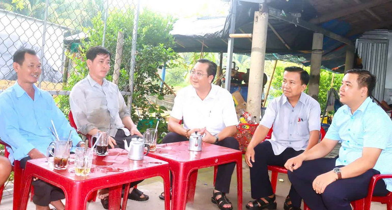 Đồng chí Phạm Quang Chiến, Phó Bí thư Thường trực Đảng ủy xã Trung Hiệp (ngồi giữa) trao đổi, chia sẻ, lắng nghe nguyện vọng của người dân về xây dựng nông thôn mới ở quê hương. (Ảnh: HUỆ TƯƠI) 79447d127c8bf1d5a89a.jpg
