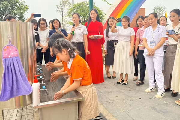 Cán bộ Trạm Y tế phường Tây Tựu hướng dẫn các em học sinh trên địa bàn rửa tay bằng xà phòng đúng cách để phòng bệnh tay chân miệng.