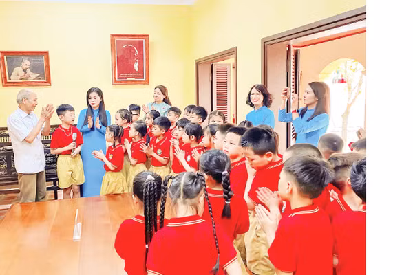 Ông Công Ngọc Dũng kể những câu chuyện về Bác Hồ với cô trò Trường tiểu học Phú Thượng khi các em học sinh học tiết học Lịch sử địa phương tại di tích Nhà cụ Nguyễn Thị An.