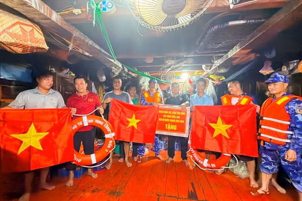 Cảnh sát biển trao quà tặng tàu cá ngư dân.