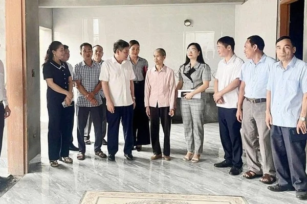 Ban Chỉ đạo xóa nhà tạm, nhà dột nát huyện Lâm Thao chia sẻ niềm vui với gia đình bà Nguyễn Thị Hữu (áo hồng đứng giữa) ở khu 5, xã Tứ Xã bên căn nhà mới.