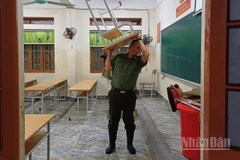 Lực lượng Công an tham gia vận chuyển bàn, ghế ở trường học lên chỗ cao.