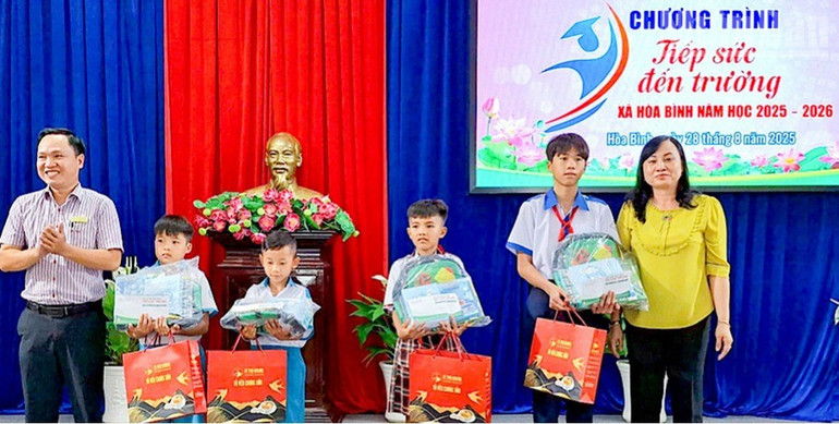 Đồng chí Đỗ Ái Lam, Phó Bí thư Đảng ủy, Chủ tịch Ủy ban nhân dân xã Hòa Bình (Cà Mau) trao quà "Tiếp sức đến trường" cho nhiều học sinh có hoàn cảnh khó khăn. (Ảnh: HỒNG ĐÀO) ndo_tr_img-3859.jpg