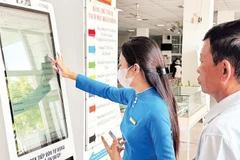 Nhân viên Bệnh viện Đa khoa Ninh Thuận, tỉnh Khánh Hòa hướng dẫn người dân đăng ký khám bệnh bằng căn cước công dân có gắn chip theo đề án 06 của Chính phủ.