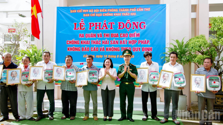 Trao tặng cờ Tổ quốc, ảnh Bác Hồ, tủ thuốc biên phòng cho ngư dân tại lễ phát động. ndo_br_thiet-ke-chua-co-ten-2.png
