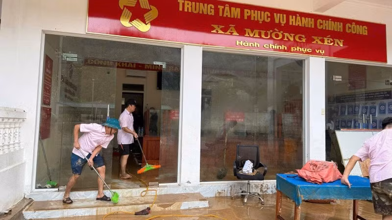 Cán bộ Phòng giao dịch Ngân hàng Chính sách xã hội Kỳ Sơn đồng hành cùng nhân dân xã Mường Xén khắc phục hậu quả lũ lụt.