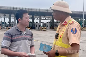 Cảnh sát giao thông tuyên truyền cho lái xe quy định mới về việc cấm xe tải lưu thông trên làn 1 tại tuyến cao tốc Pháp Vân-Cầu Giẽ.