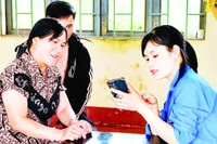 Thành viên Tổ dịch vụ công trực tuyến cộng đồng xã Đức An, tỉnh Lâm Đồng về tận cơ sở hướng dẫn người dân thực hiện dịch vụ công trực tuyến.