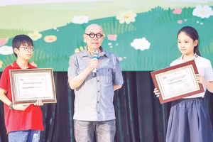 Họa sĩ Thành Chương chia sẻ niềm vui với các tác giả nhí nhận Giải thưởng Thiếu nhi Dế Mèn. (Ảnh: MAI AN)