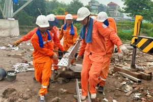 Công nhân Công ty Dịch vụ Điện lực Hà Nội tăng cường cho Dự án đường dây 500kV mạch 3 từ Quảng Trạch đến Phố Nối (đoạn Nam Định-Thanh Hóa). (Ảnh: VŨ CHUNG)
