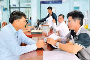 Cán bộ xã Đất Mũi (Cà Mau) hướng dẫn người dân thực hiện các thủ tục hành chính.