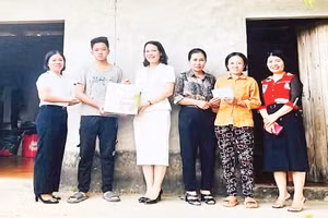Thầy, cô giáo Trường trung học phổ thông Tam Đảo trao quà, đồ dùng học tập tặng em Trần Văn Thiên.