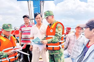 Cán bộ, chiến sĩ Đồn Biên phòng An Hải trao đổi trực tiếp với ngư dân về các thủ tục, giấy tờ liên quan chuyến biển.
