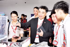 Lãnh đạo Đại học Bách khoa Hà Nội trao đổi với sinh viên về sản phẩm nghiên cứu khoa học tại một triển lãm.