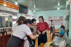 Đồng chí Ngô Thị Minh Trinh (bên phải)- Bí thư Đảng ủy xã Ea Knuếc, tỉnh Đắk Lắk, cùng cán bộ xã đang chỉ dẫn cho người dân làm thủ tục trên cổng dịch vụ công điện tử. (Ảnh LINH CẦM) 
