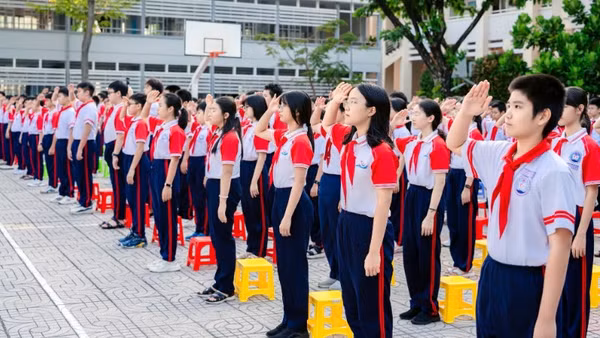 Học sinh Trường trung học cơ sở Nguyễn An Ninh, phường Tam Thắng, Thành phố Hồ Chí Minh chào cờ. 