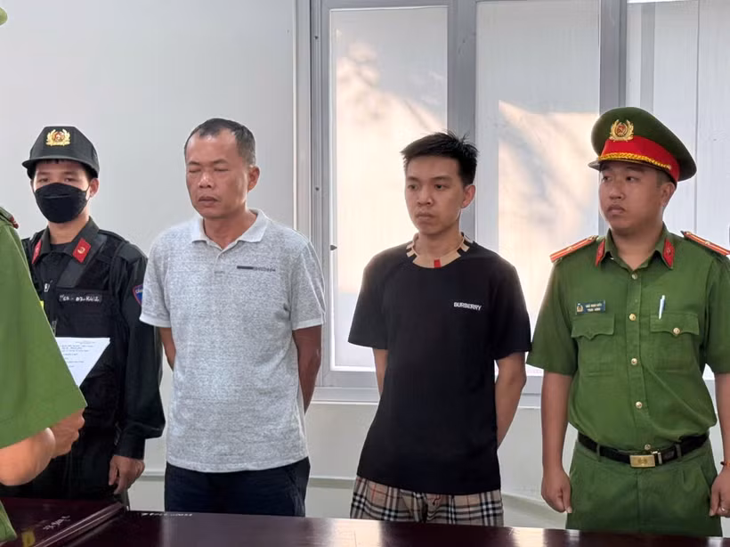 Đặng Trần Quốc Vũ (áo trắng) và Đào Năng Nghĩa (áo đen) nghe đọc lệnh tạm giữ hình sự.