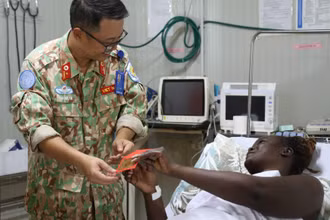  Thiếu tá Trần Đức Tài, Giám đốc Bệnh viện dã chiến cấp 2 số 7 thăm hỏi, chúc Tết các bệnh nhân đang điều trị tại bệnh viện. (Ảnh: TIẾN PHÚC)