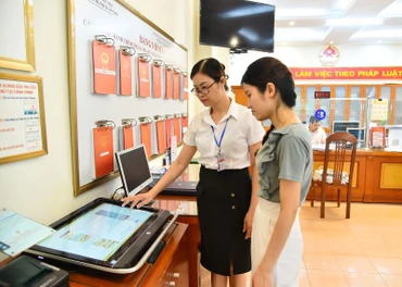 Cán bộ Ủy ban nhân dân phường Thanh Xuân Nam (quận Thanh Xuân, Hà Nội) hướng dẫn quy trình thực hiện thủ tục hành chính cho người dân. Thời gian tới, phường Thanh Xuân Nam sẽ được sáp nhập với phường Thanh Xuân Bắc để thành lập đơn vị hành chính mới. (Ảnh: THỦY NGUYÊN)