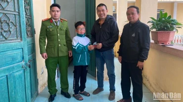 Em Nguyễn Bá Nhất, lớp 6A, Trường Tiểu học và Trung học cơ sở xã Quỳnh Minh, Quỳnh Phụ, tỉnh Thái Bình (thứ 2 từ trái qua) trao trả tài liệu cùng 19,5 triệu đồng nhặt được cho người bị đánh rơi.