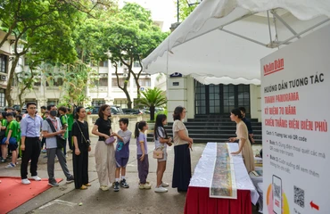 Bạn đọc xếp hàng để nhận ấn bản đặc biệt của Báo Nhân Dân in tranh panorama Chiến dịch Điện Biên Phủ.