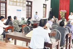 Cán bộ xã đối thoại với người dân có đất được thu hồi để triển khai dự án điện.