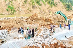 Công nhân Công ty cổ phần đường bộ 2 tập trung khắc phục Quốc lộ 12, đoạn Km 261+900 (Pá Vạt-Mường Luân) bị lũ cuốn mất toàn bộ mặt đường.