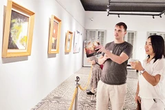 Khách xem tranh trong trưng bày chuyên đề "Trở về" tại Bảo tàng Mỹ thuật Thành phố Hồ Chí Minh. (Ảnh ĐÔNG A)