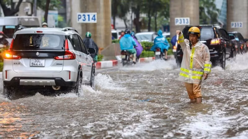 Cán bộ Phòng Cảnh sát giao thông, Công an TP Hà Nội điều tiết giao thông tại các điểm ngập sâu. (Ảnh: Văn Huế)