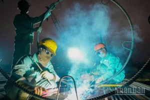 Những ngày cận Tết Nguyên đán, ngày cũng như đêm, trên công trường xây dựng cầu Trần Hưng Đạo (Hà Nội), nhịp độ lao động vẫn hết sức sôi động, khẩn trương.