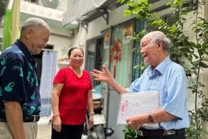 Ông Nguyễn Khắc Êm (áo xanh) trò chuyện cùng người dân trong khu phố. 