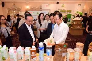 Lãnh đạo Ủy ban nhân dân Thành phố Hồ Chí Minh trao đổi, tham quan gian hàng có sản phẩm tái chế bên lề hội thảo. (Ảnh: QUANG ĐỊNH)