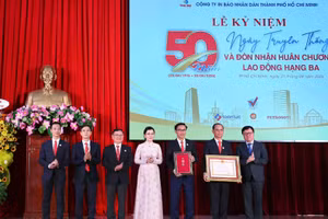 Đồng chí Lê Quốc Minh, Tổng Biên tập Báo Nhân Dân thừa ủy quyền của Chủ tịch nước trao Huân chương Lao động hạng Ba đến Công ty In Báo Nhân Dân tại Thành phố Hồ Chí Minh. (Ảnh: TRỌNG ANH)