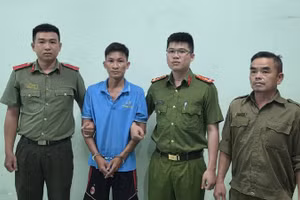 Đối tượng Bùi Trung Quốc (áo xanh) tại Cơ quan Công an. (Ảnh: Công an cung cấp)