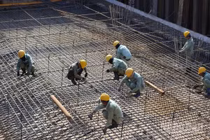 Công nhân duy trì nhịp độ làm việc khẩn trương trên công trường dưới thời tiết khắc nghiệt. (Ảnh: ÁNH DƯƠNG)