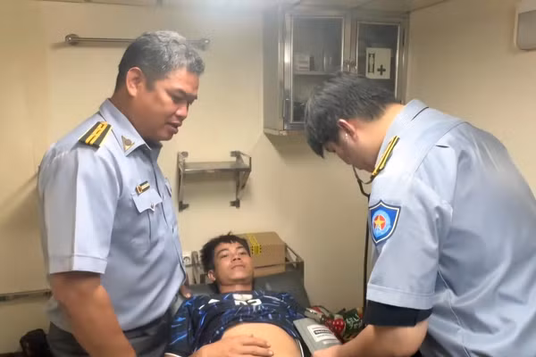 Tổ y tế tàu KN 278 đang khám bệnh cho ngư dân Nguyễn Hữu Thọ. (Ảnh:Chi đội Kiểm ngư số 2 cung cấp)