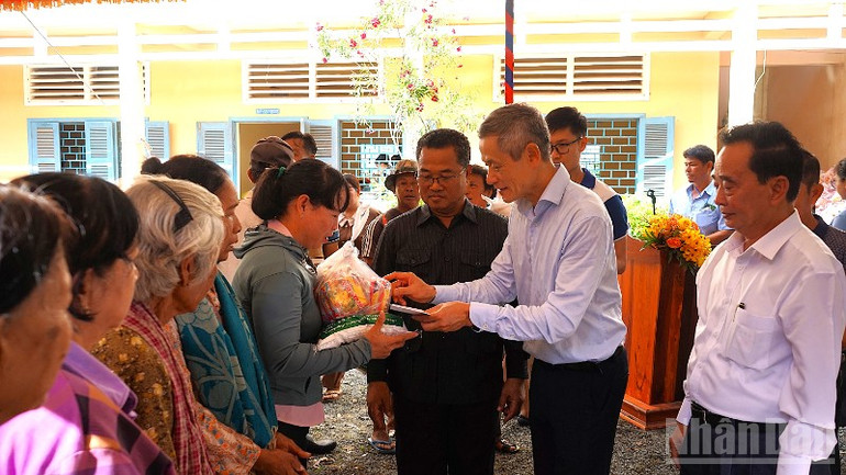 Đại sứ Nguyễn Minh Vũ cùng các đại biểu trao quà tặng người dân đến tham gia chương trình. (Ảnh: HUY VŨ) ndo_br_dsc06808-4308.jpg