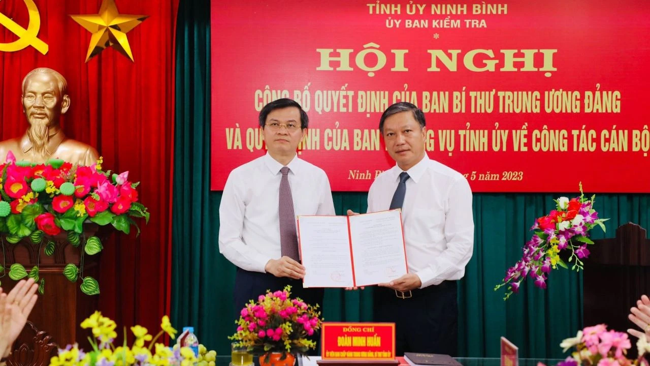 Đồng chí Đoàn Minh Huấn, Ủy viên Trung ương Đảng, Bí thư Tỉnh ủy Ninh Bình trao Quyết định của Ban Bí thư Trung ương Đảng cho đồng chí Đinh Việt Dũng. (Ảnh: ĐỨC LAM)