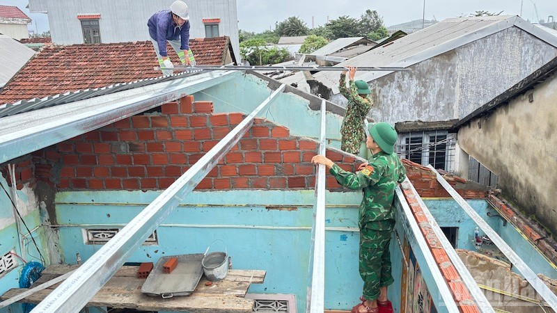 Cán bộ và chiến sĩ Đồn Biên phòng cửa khẩu cảng Dung Quất sửa chữa, xây dựng nhà cho người dân ven biển.