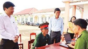Lãnh đạo xã Bù Đăng hỗ trợ nhân dân giải quyết thủ tục hành chính.