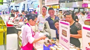 Người tiêu dùng thanh toán tại siêu thị AEON. (Ảnh ĐỖ TÂM)