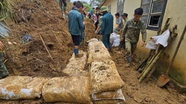Cán bộ, chiến sĩ Ban Chỉ huy Bộ đội Biên phòng tỉnh Điện Biên cùng người dân dọn nhà cửa, khắc phục hậu quả do lũ quét. (Ảnh: LÊ LAN)