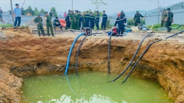 Lực lượng chức năng bơm hút nước tìm kiếm nạn nhân. (Ảnh: TUẤN SƠN)